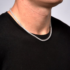 This is a side shot closeup of a model wearing our 4mm sterling silver moissanite tennis necklace