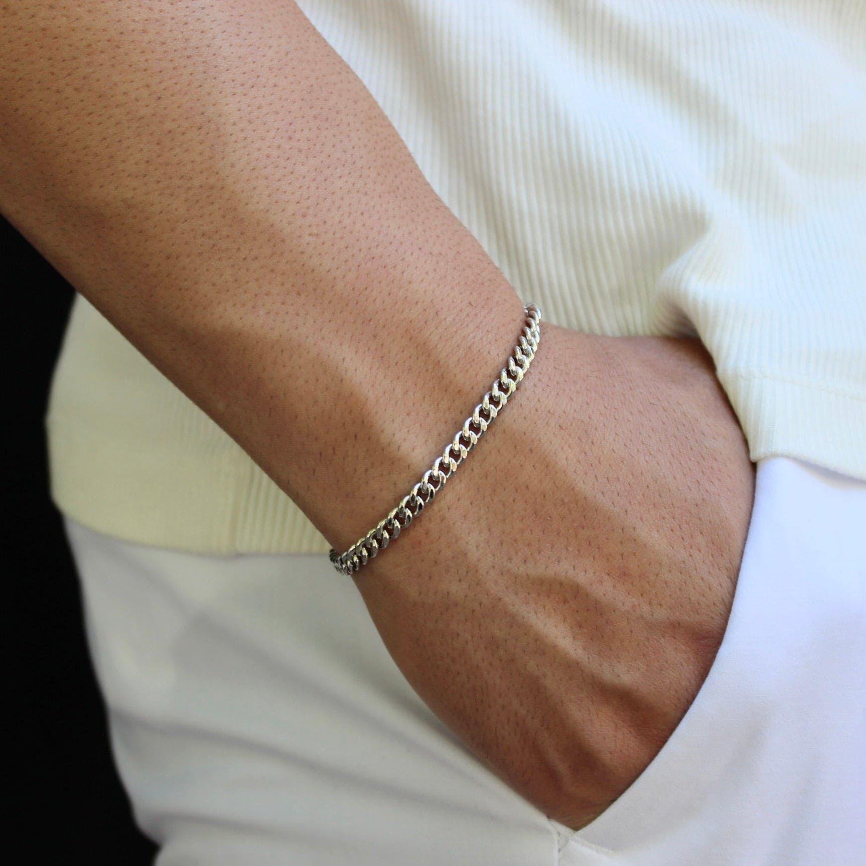 This is a close-up shot of our 5mm sterling silver cuban bracelet on our models wrist with the models hand in there pocket