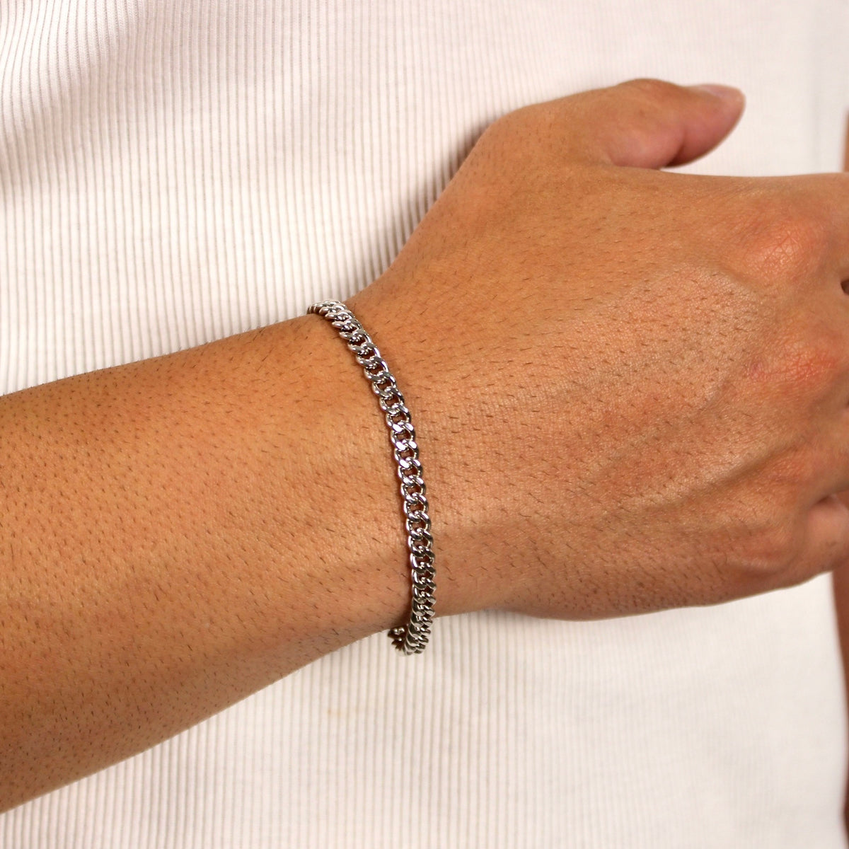 This is a close-up shot of our 5mm sterling silver cuban link bracelet being worn on a models wrist