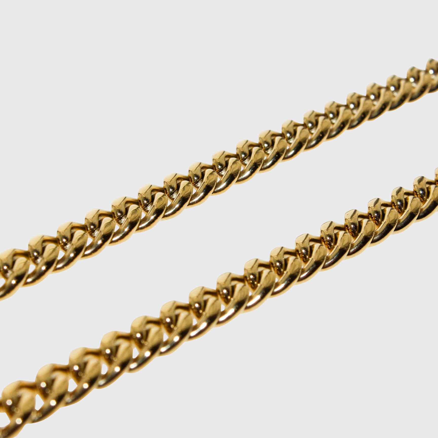 This is an extreme close-up product shot of our 6mm yellow gold cuban chain on a white backround