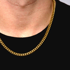 This is an extreme close up shot of our 6mm yellow gold cuban link chain with lobster clasp on models neck.