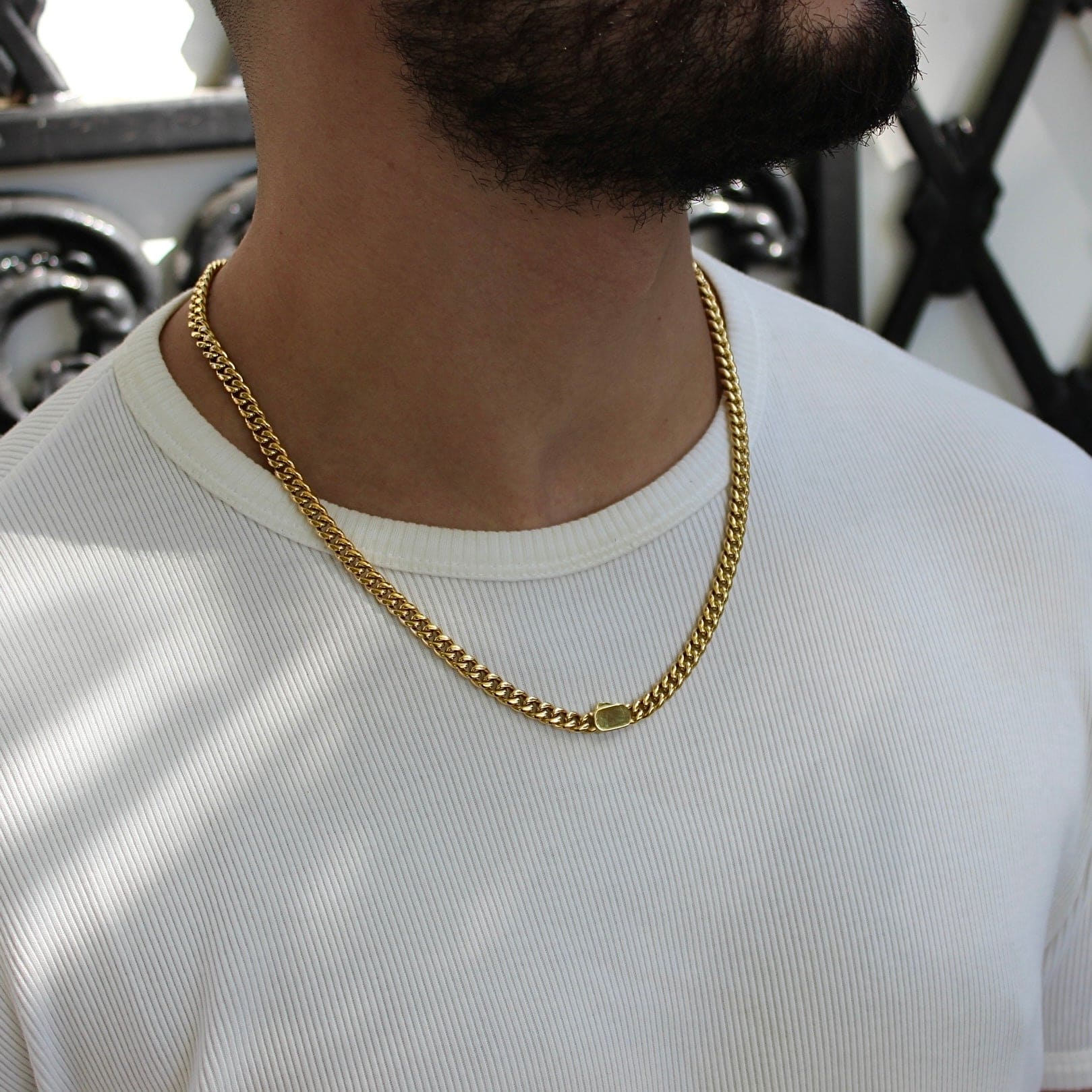 This is a shot of our 6mm yellow gold cuban link chain, being worn by a model with the box clasp being shown