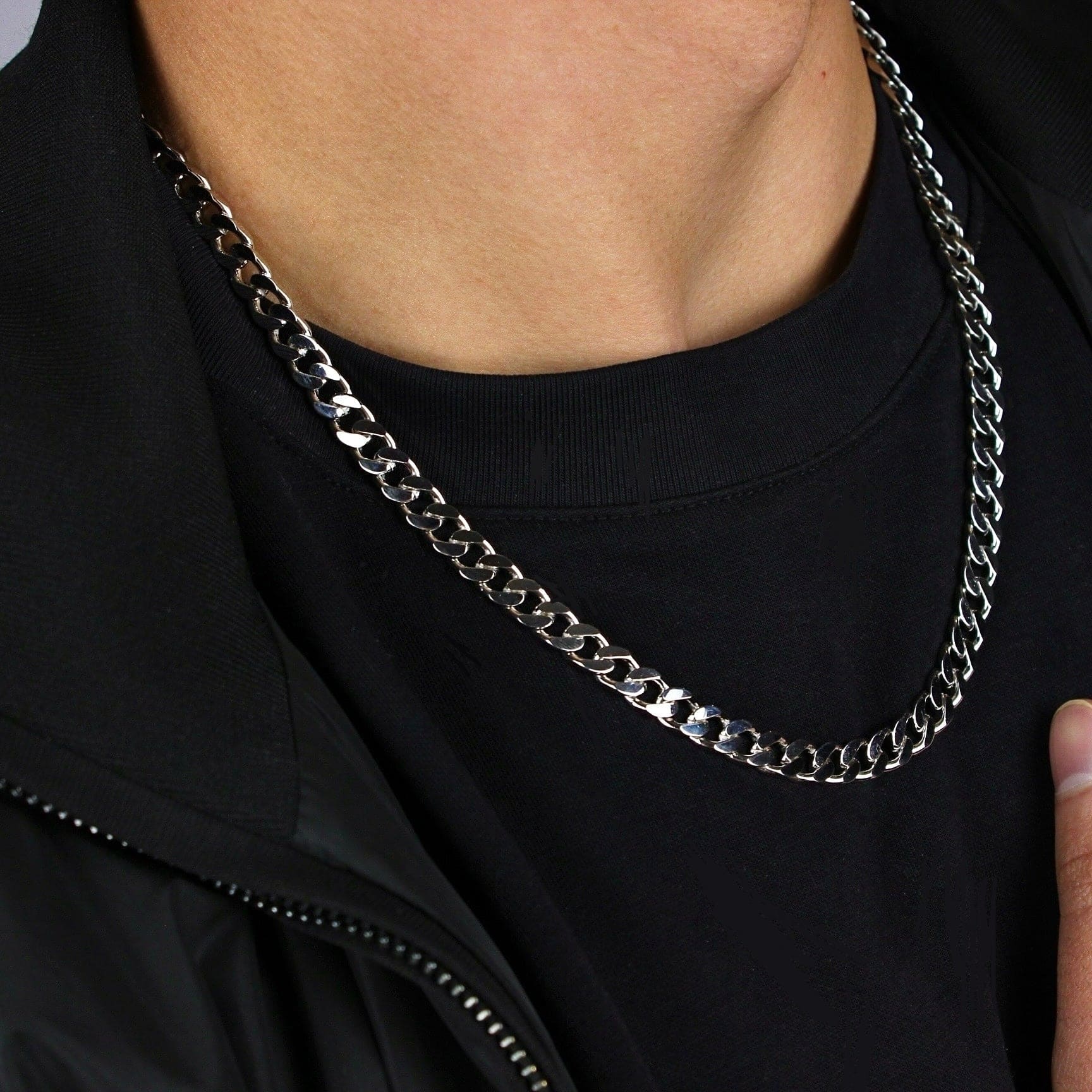 This is a side close up shot taken in a studio of a models neck, wearing our 7mm sterling silver cuban link chain.