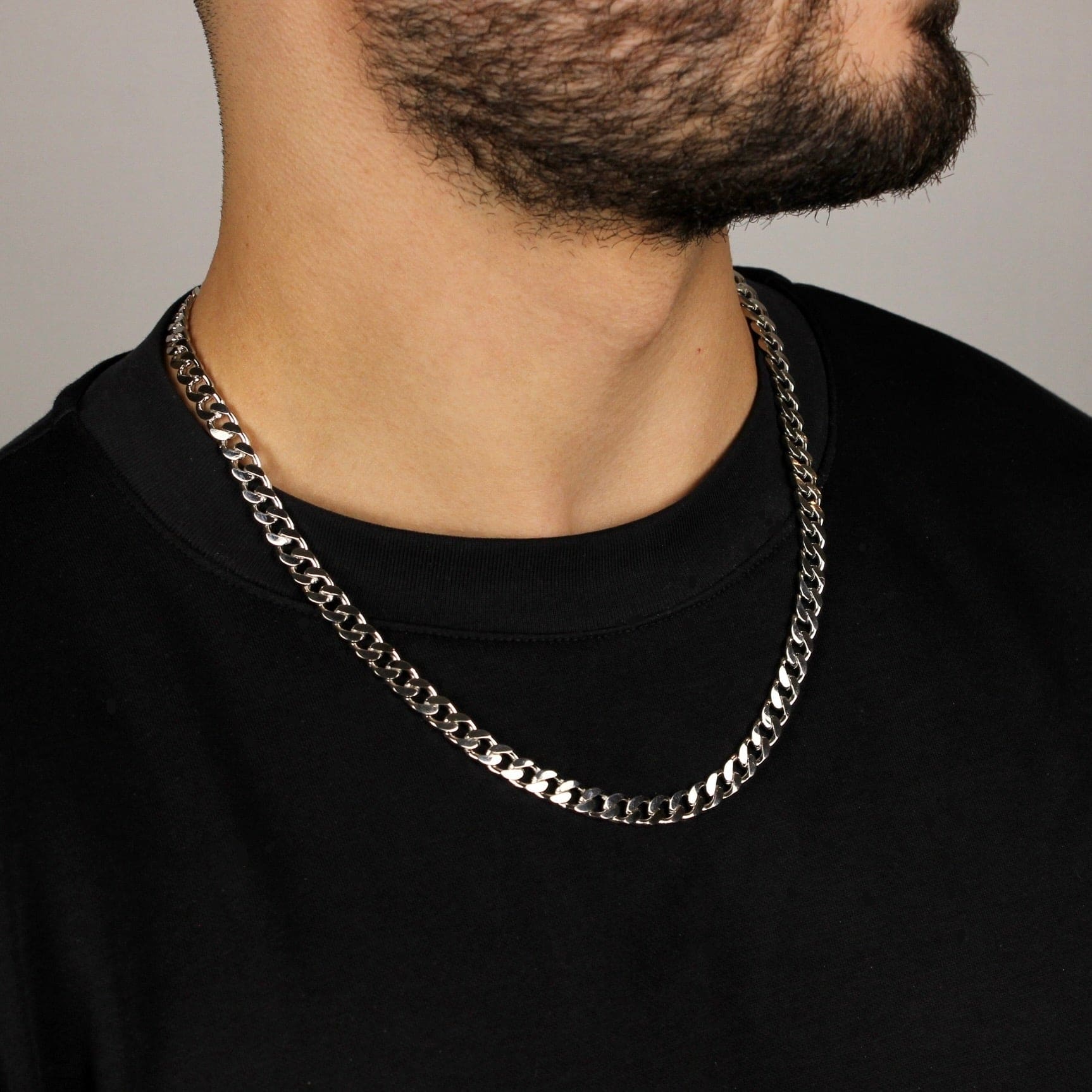 This is mid shot of our model wearing our 7mm sterling silver cuban link chain around his neck