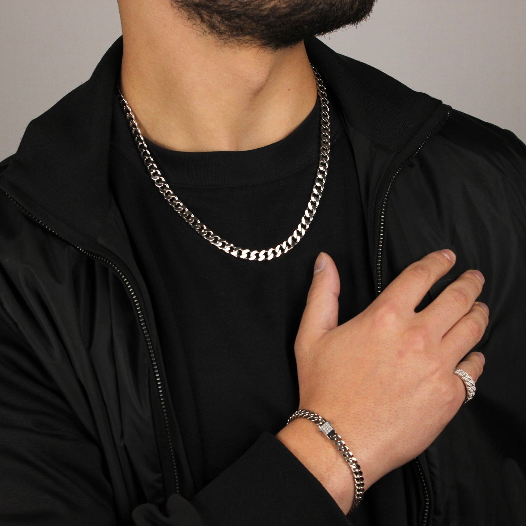 This is a zoomed out shot of our 7mm sterling silver cuban link chain being styled with a bracelet and ring