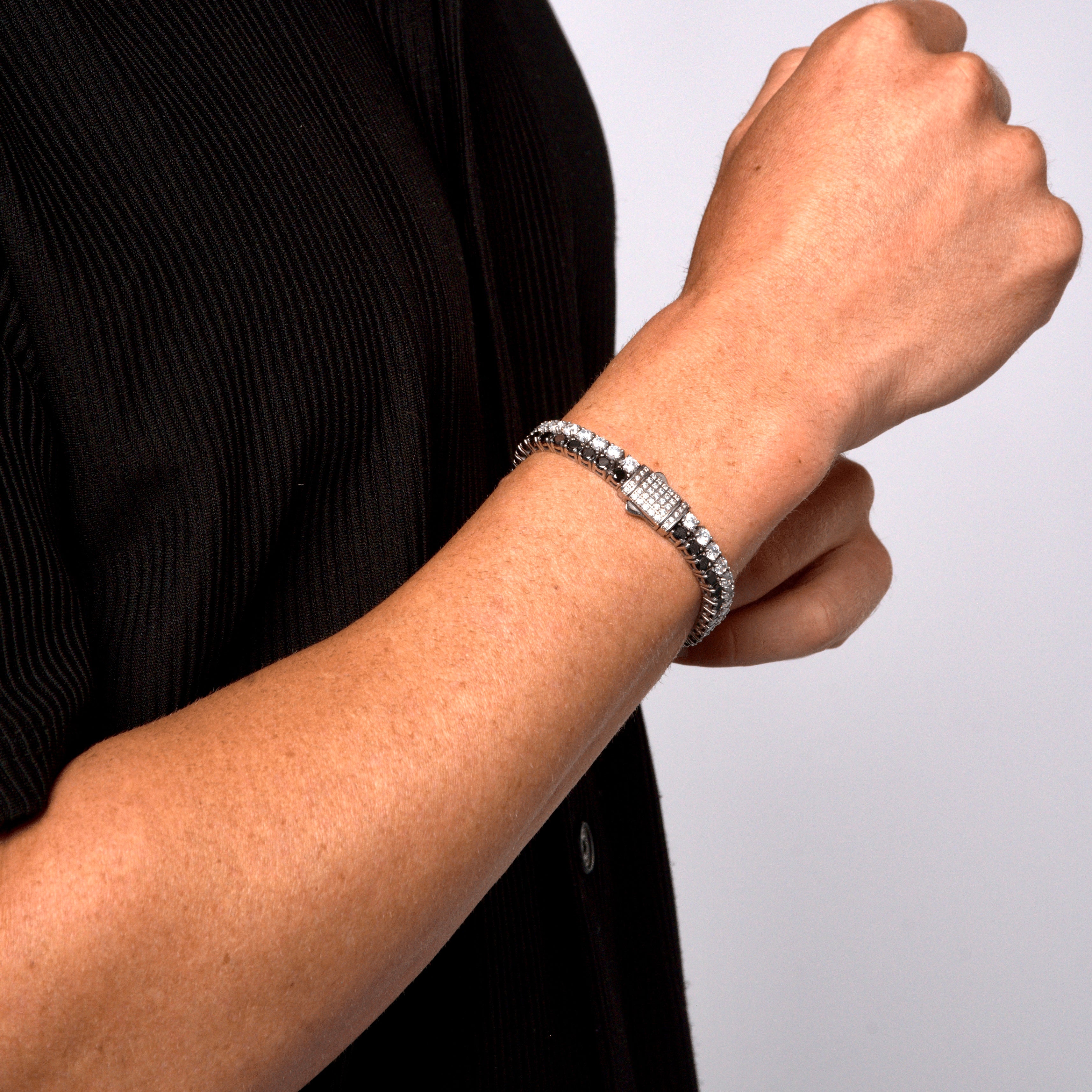 This is a side shot taken in a studio of a models wrist, wearing our 8mm dual white & black tennis bracelet with the clasp being displayed