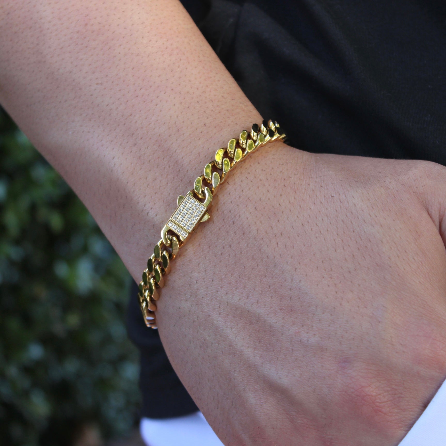 This is a close up shot of our 8mm yellow gold cuban link bracelet on our models wrist with the clasp being displayed