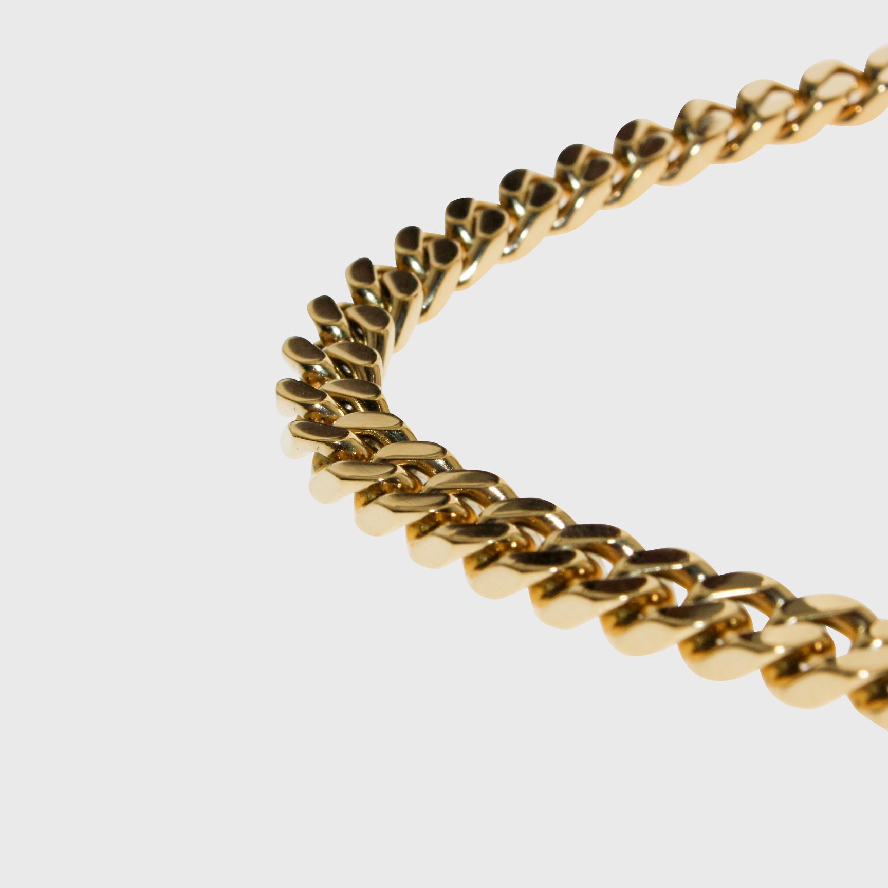 This is a close up light box product shot of our 8mm yellow gold cuban link chain